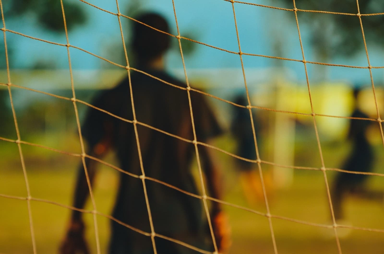 A goalkeeper seen through the goal net